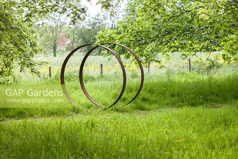 Moongates - circles of mild steel - set in long grass
