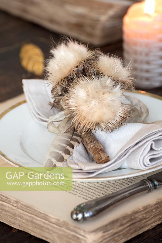 Dried fluffy seedhead place setting on vintage book charger