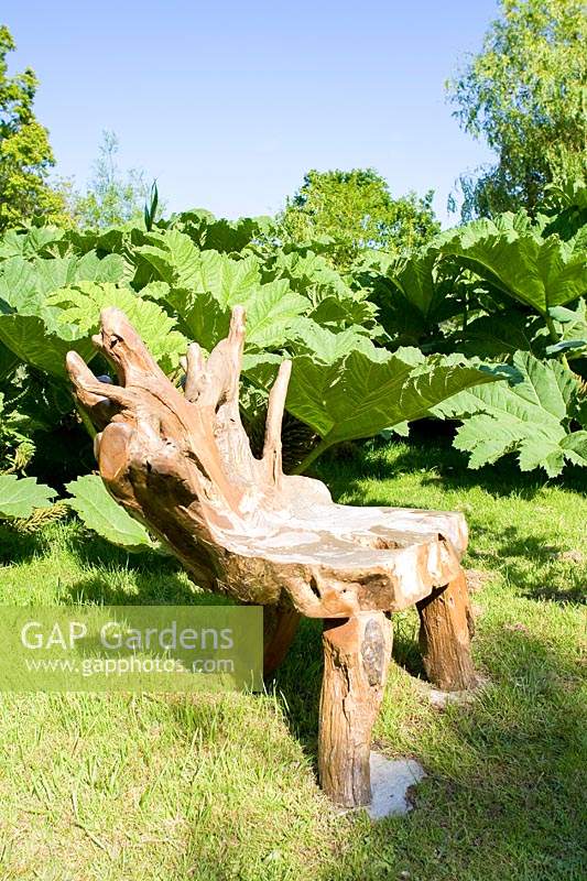 Carved wooden chair in garden. 