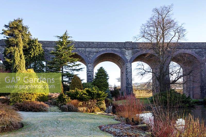View to evergreen trees and the viaduct at Kilver Court, Somerset, UK. 
 Designed by Roger Saul of Mulberry. 