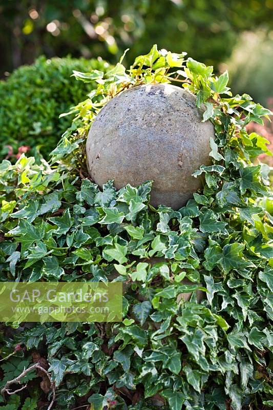 Sphere on pedestal covered with Hedera helix - Ivy. 