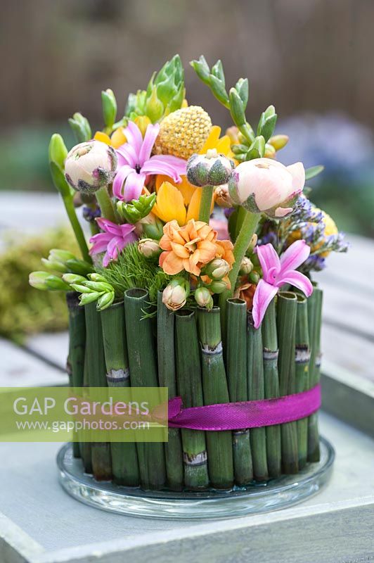 Easter floral arrangement displayed in a vessel made of cut Equisetum - Horsetail stems. 

