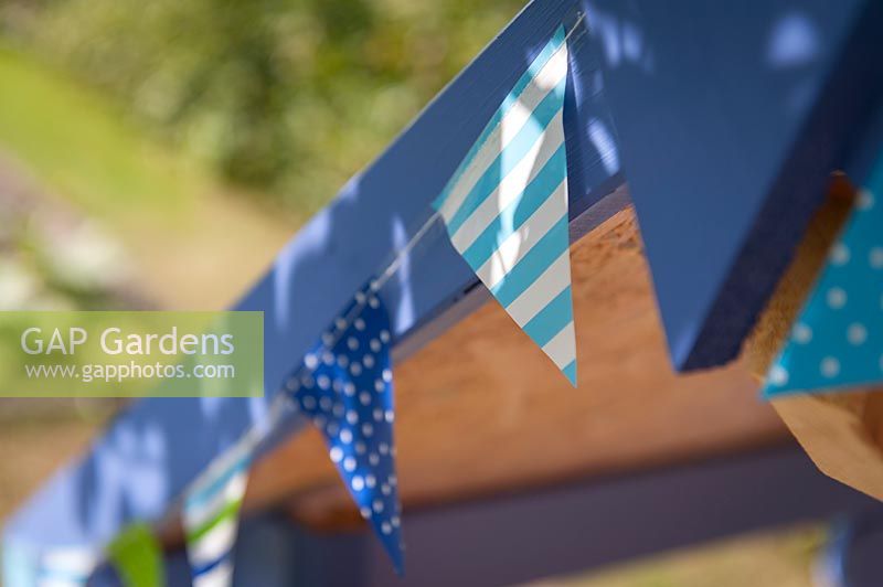 Detail of blue bunting on painted children's playhouse. 