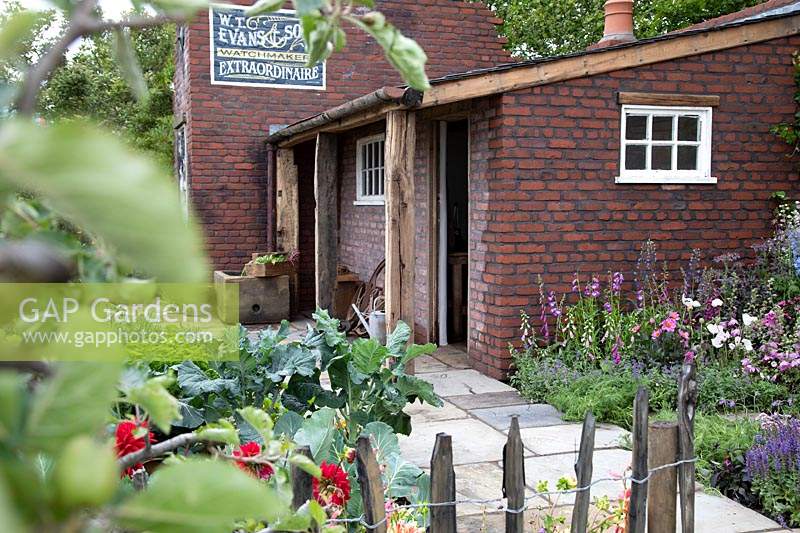 The Watchmakers' Garden at BBC Gardeners World Live 2019 - A view of watchmakers cottage surrounded by cottage planting