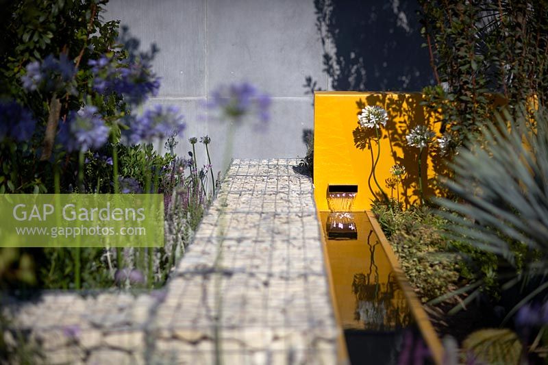 Water feature next to granite gabions. Santa Rita 'Living La Vida 120' Garden. Designed by Alan Rudden. Sponsored by Santa Rita Wines. RHS Hampton Court Palace Show, 2018.