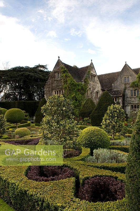 Clipped Buxus and Berberis Knot garden with topiarised evergreens at Abbey House Gardens, Malmesbury, UK. 