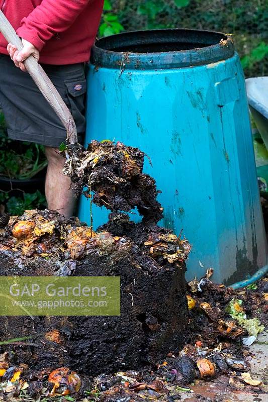 Turning compost back into bin to access the most composted material 