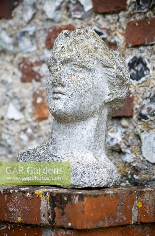 Classic bust - statue of face and head on garden wall 