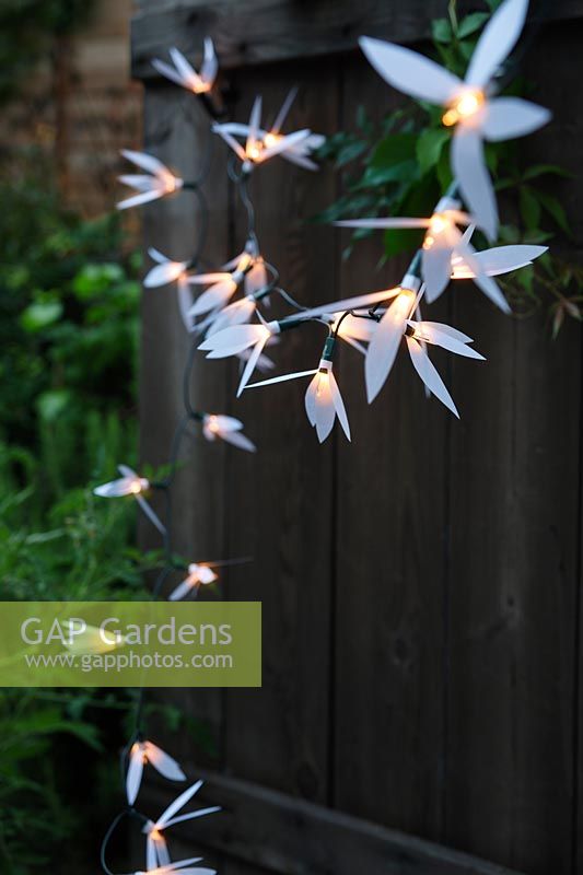 Fairylights decorated with white paper shapes to create beautiful decorative outdoor lighting