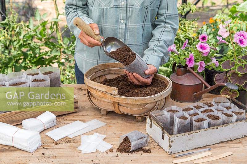 Woman filling the bio pot with compost using a scoop. 