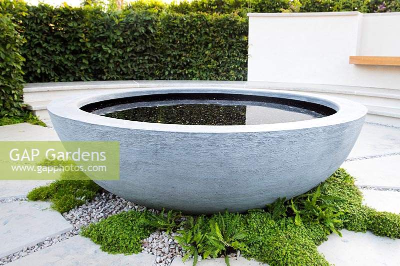 Concrete round water feature. The South West Water Green Garden at RHS Hampton Court Palace Flower Show 2018 