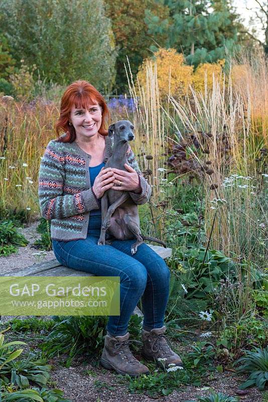 Sarah Murch, garden designer, with Luka, an Italian greyhound, in her garden in autumn.
