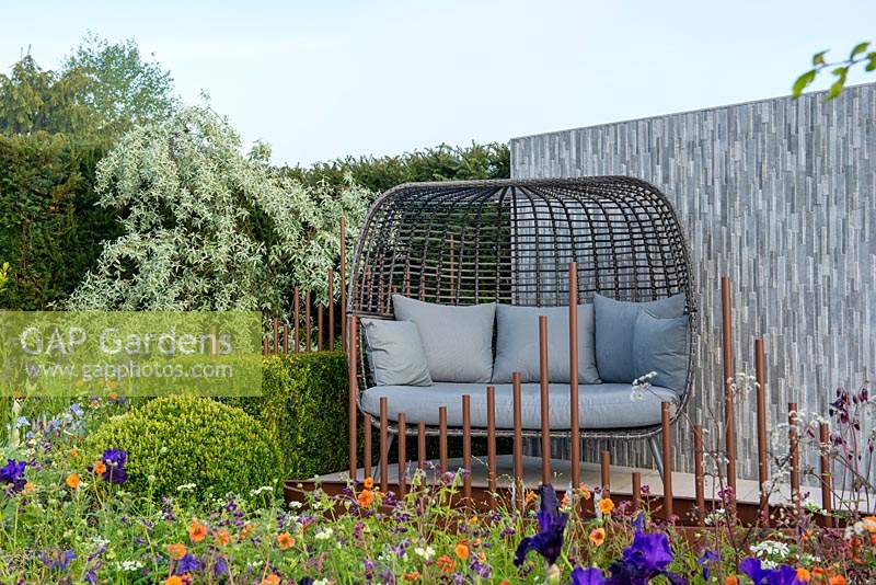 Curved box hedge surrounded a seating area with feature porcelain wall, RHS Malvern Spring Festival 2019, in support of Diabetes UK.