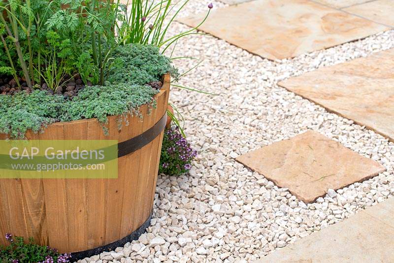 Wooden barrel with herbs on a patio with white gravel and paving - Ikhaya: Home - Green Living Spaces, RHS Malvern Spring Festival 2019