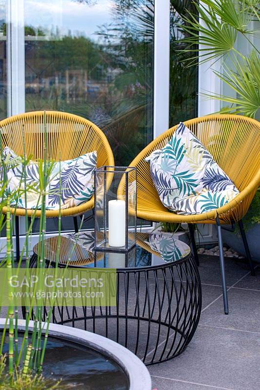 Contemporary table and chairs with storm lantern on a balcony - Defiance - Green Living Spaces, RHS Malvern Spring Festival 2019
