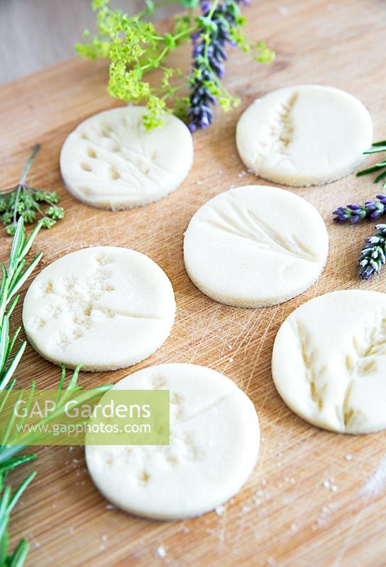Circular salt dough discs with impressions left by flowers 