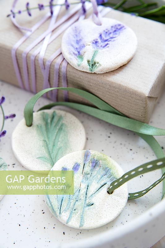 Wrapped present with gift tags made of salt dough and painted pressed flowers 
