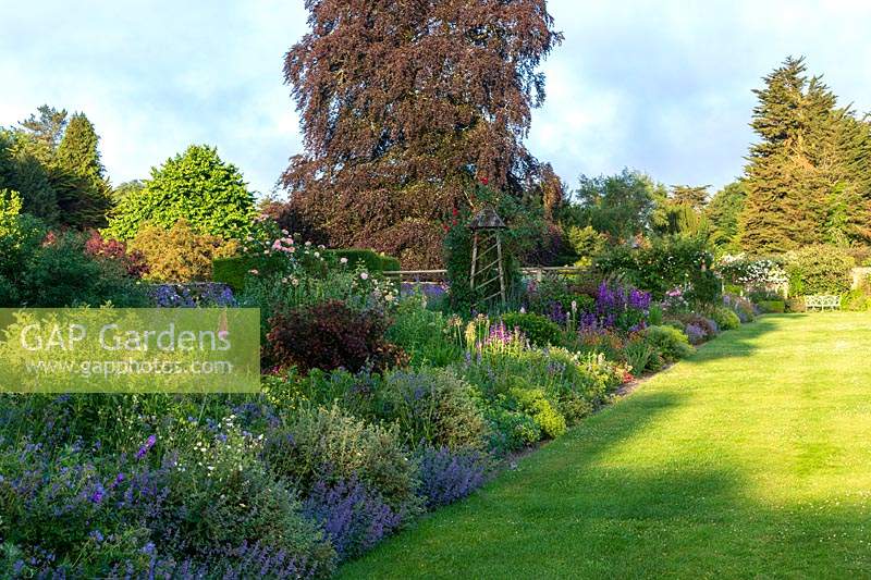 Miserden Park, Gloucestershire. The large double borders overflowing with summer planting.