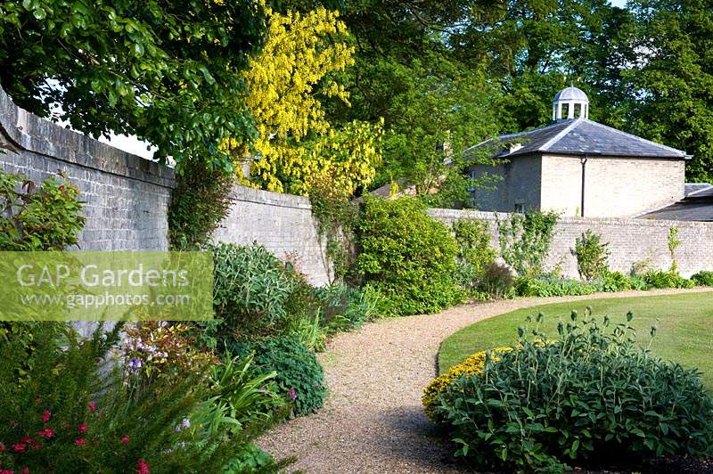 View of curved borders and pathway in walled garden at  Hoveton Hall Gardens, Norwich, UK. 