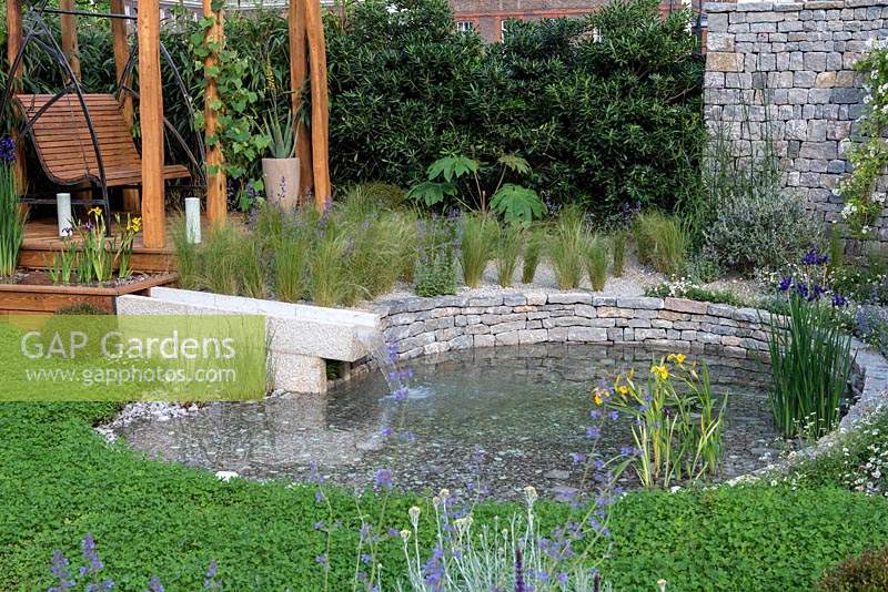 The Harmonious Garden of Life. An environmentally sustainable courtyard with a pond that is kept clean by a reed bed, encircled in clover to enrich the soil. A pergola swingseat is edged in bamboo to purify the air. Sponsors: Mr and Mrs Cawthorn, Margheriti Piante.