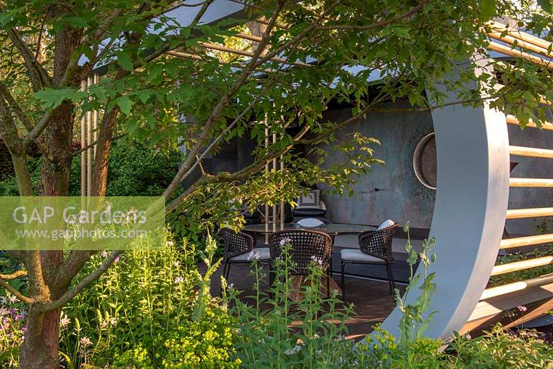 Seating in a contemporary relaxation pod with bamboo flooring - The Morgan Stanley Garden, RHS Chelsea Flower Show 2019.
