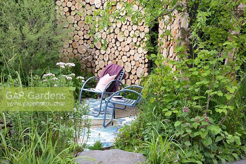 Viking Cruises: The Art of Viking Garden, view of the terrace and its feature wall of logs with planting at the front including Valeriana officinalis. Sponsor: Viking.