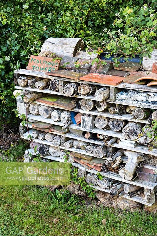 Bug hotel made of wood and tiles in sandwiched layers 
