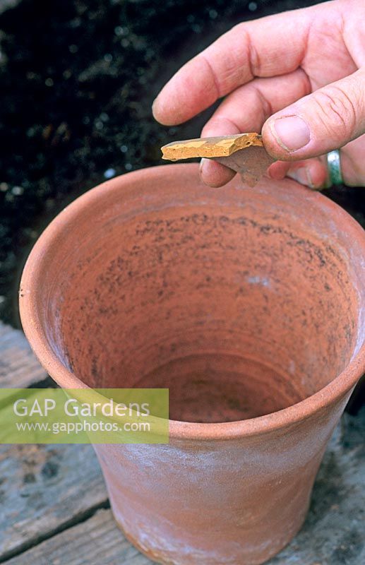 Placing a crock to cover the drainage hole of a clay pot