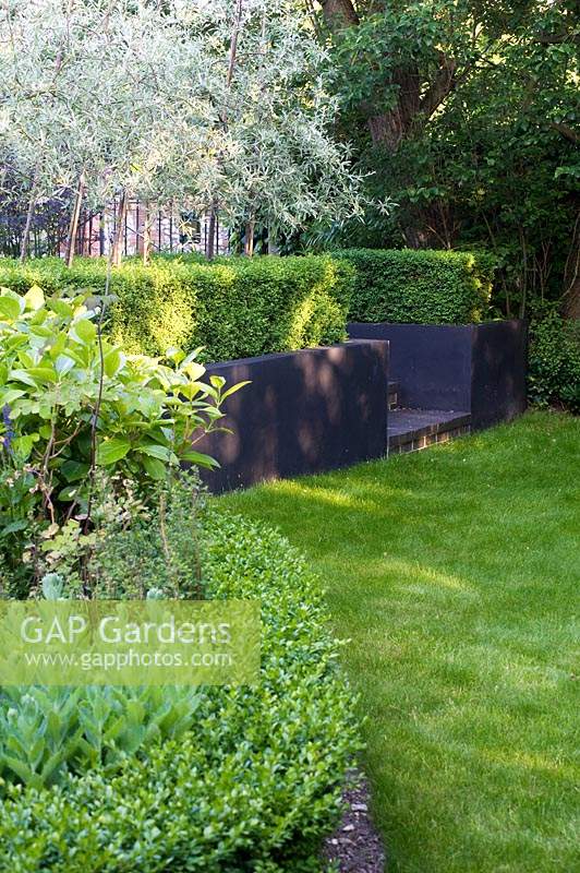 Different greens and textures compliment each other in border, set off by black raised border. 