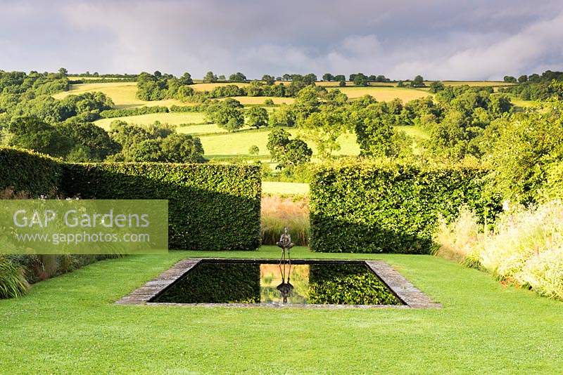 The bronze garden, with a reflecting pool at its centre with hedging.