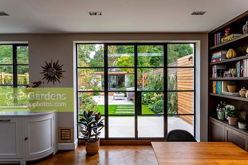 Contemporary garden in Wandsworth. View from kitchen through window into garden.