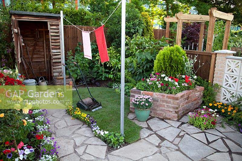 Shed, crazy paving, lawnmower, and washing line in the 1960's Anniversary Garden at BBC Gardener's Live 2017.