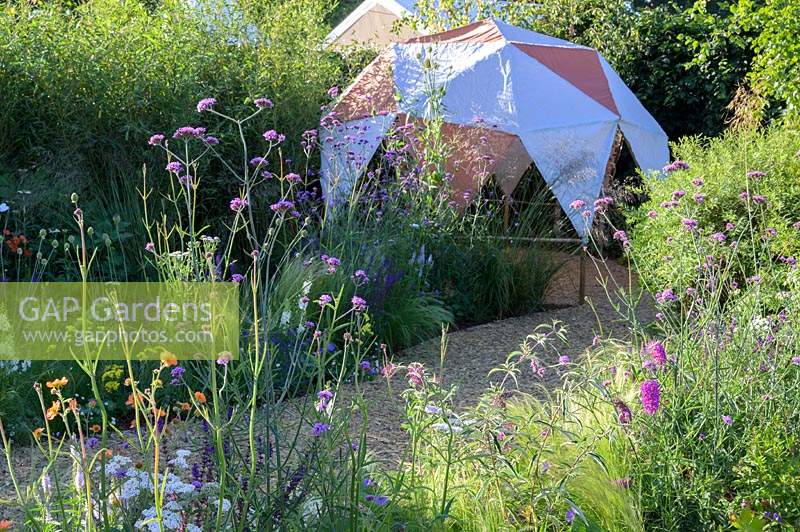 Summer borders with path leading to canopy - The Year of Green Action Garden - RHS Hampton Court Palace Garden Festival 2019. Sponsors: Defra.