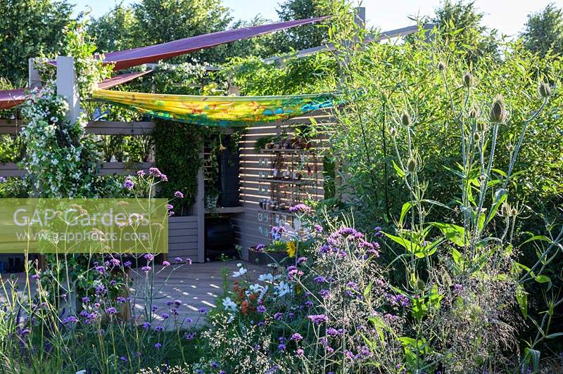 Outdoor room with removeable canvas canopy roof, plant screen and planting of herbs and vegetables, with Nasturtiums and climbing french beans - The Year of Green Action Garden - RHS Hampton Court Palace Garden Festival 2019 - Designers: Helen J Rosevear and Jane Stoneham - Sponsors: Defra.
