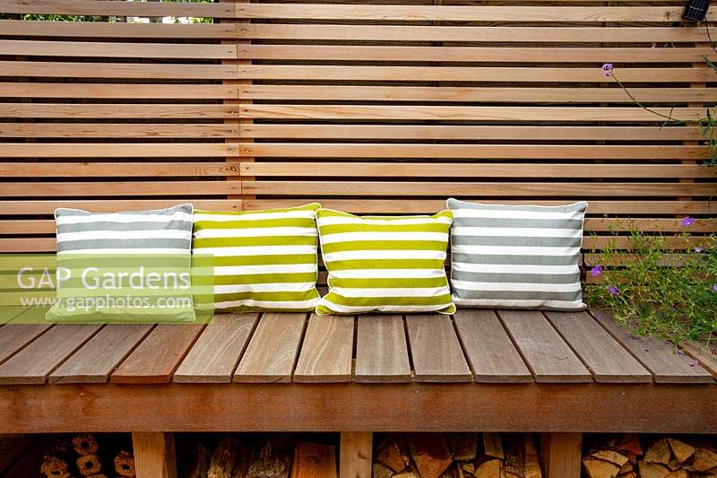 London contemporary garden -  lower wood deck area with  wooden seat and cushions