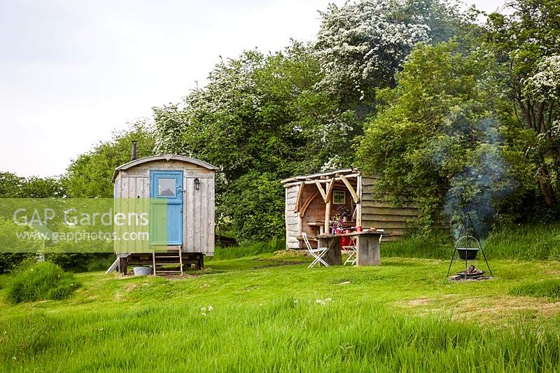 View to rustic kitchen hut and shepherds hut at wild Meadows 