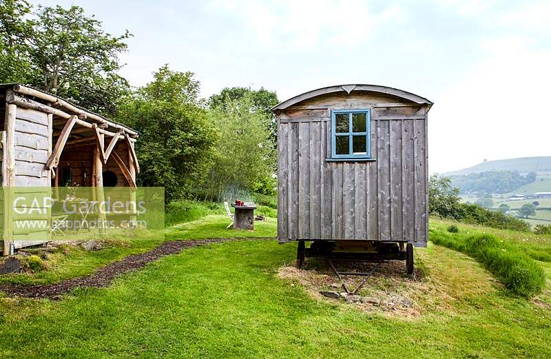 View to rustic kitchen hut and shepherds hut at wild Meadows. 