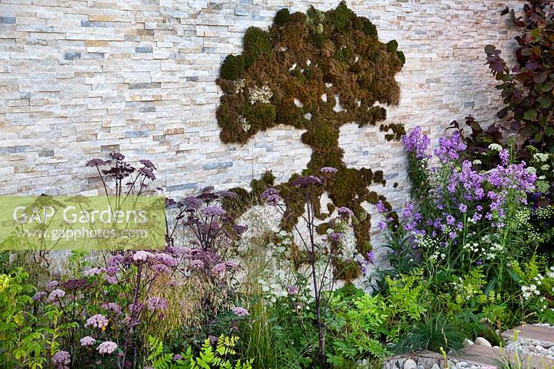 Decorative moss in shape of a tree on the stone wall in the 'Wetland Plants - The idea of Wilderness' garden 