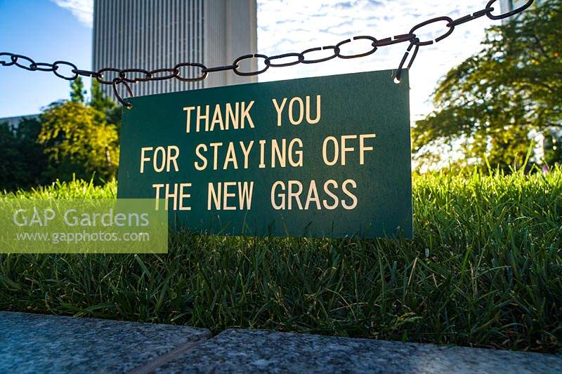 Sign: 'Thank You for Staying Off the New Grass'.