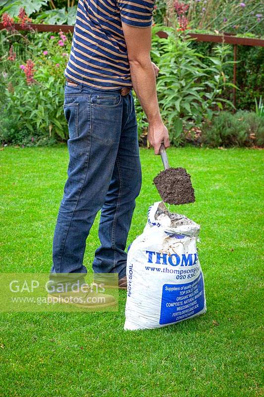Top dressing a lawn with soil