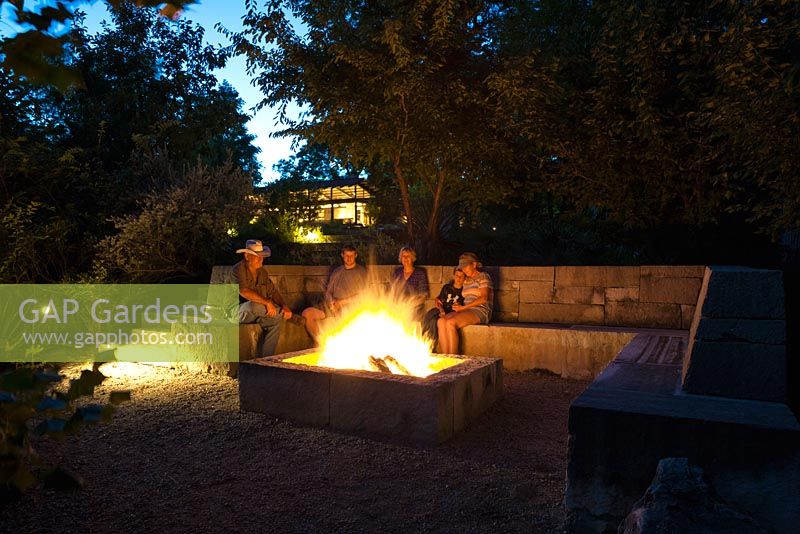 Family seated around the fire pit at Mill Creek Ranch Vanderpool, Texas designed by Ten Eyck Landscape Inc, July.