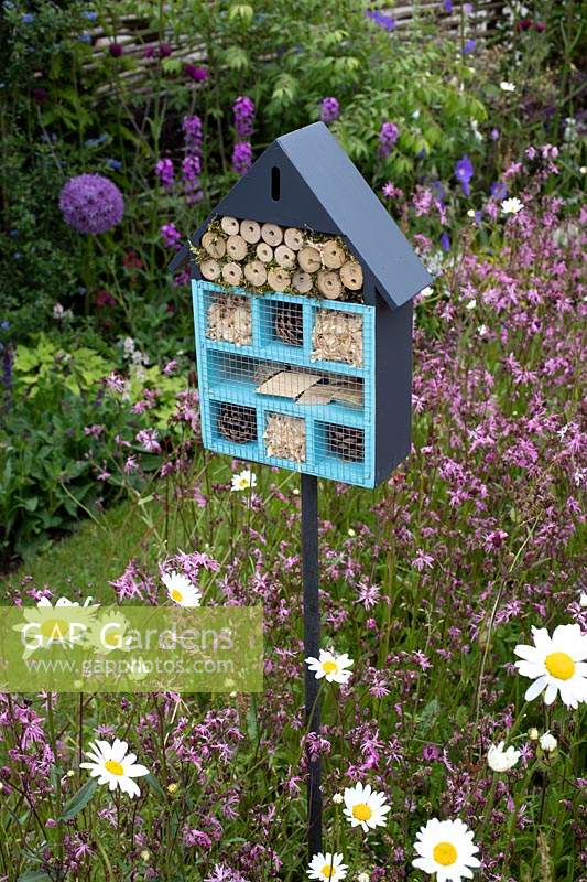 Insect hotel set amongst wildflowers in the 'RHS Garden for Wildlife Wild Woven' - RHS Chatsworth Flower Show 2019.