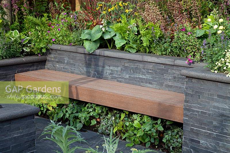 Slat seating amongst slate walls and raised beds in 'The Square Garden' at BBC Gardner's World Live 2018.