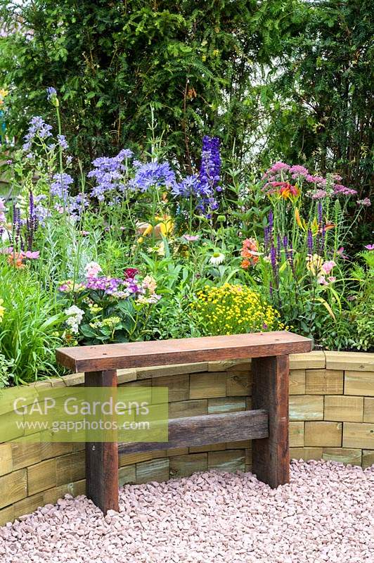 Simple wooden bench in front of raised bed with flowerbed -The Therapeutic Garden - RHS Hampton Court  Palace Garden Festival 2019  - Sponsor: Southend-on-Sea Council, Wood BlocX FormaraPrint 