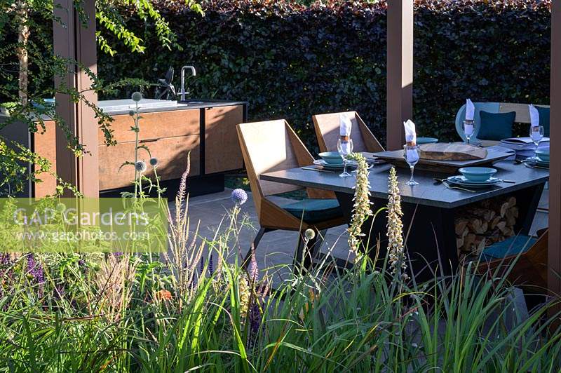 Outdoor dining set table and chairs. The Lower Barn Farm Outdoor Living Garden. RHS Hampton Court Palace Garden Festival, 2019.