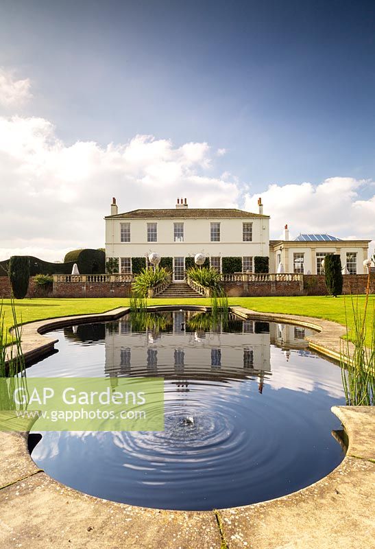 View to Littlethorpe Manor across the Fountain Pool and lawn. Yorkshire, UK. Designed by Eddie Harland.