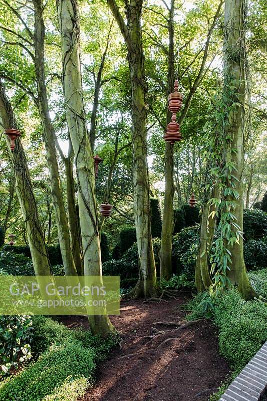 Terracotta sculptures hanging from trees by Sergei Katran in the Jardin Zin. Les jardins d Etretat, Normandy, France