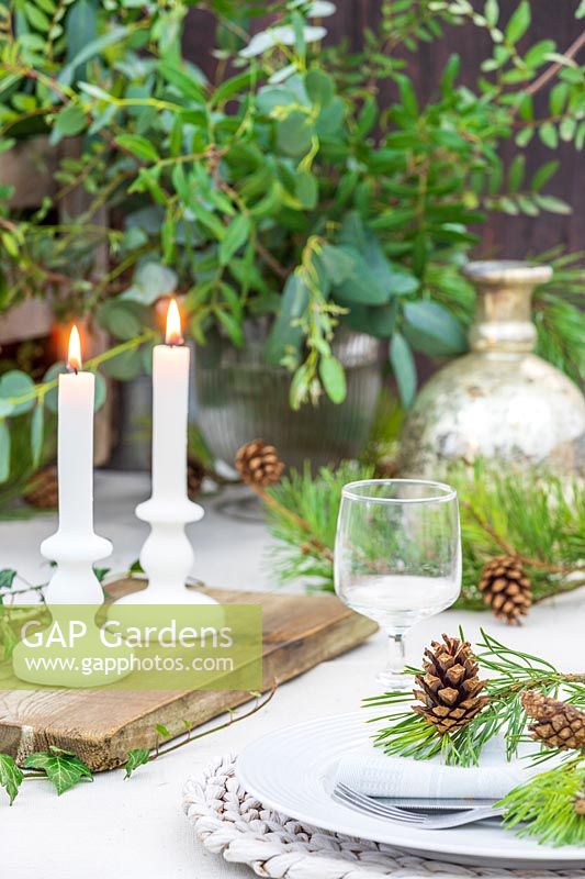 White candles on wooden board as table decoration