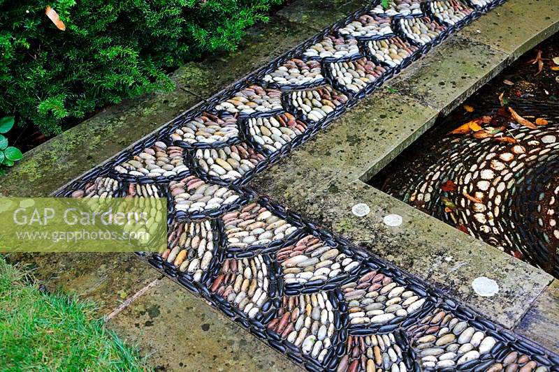 Corner of pond edge with pebble mosaic pattern