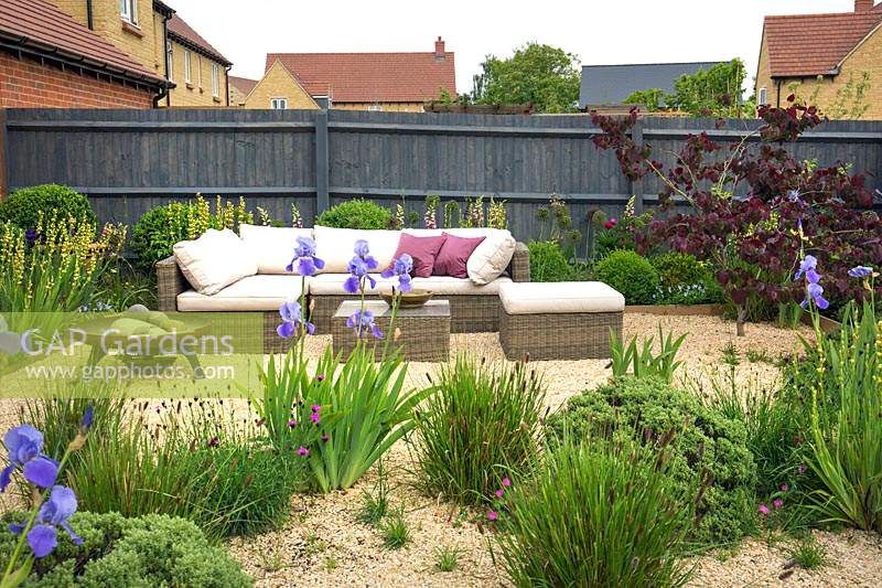 Gravel garden with rattan outdoor furniture and a fire bowl